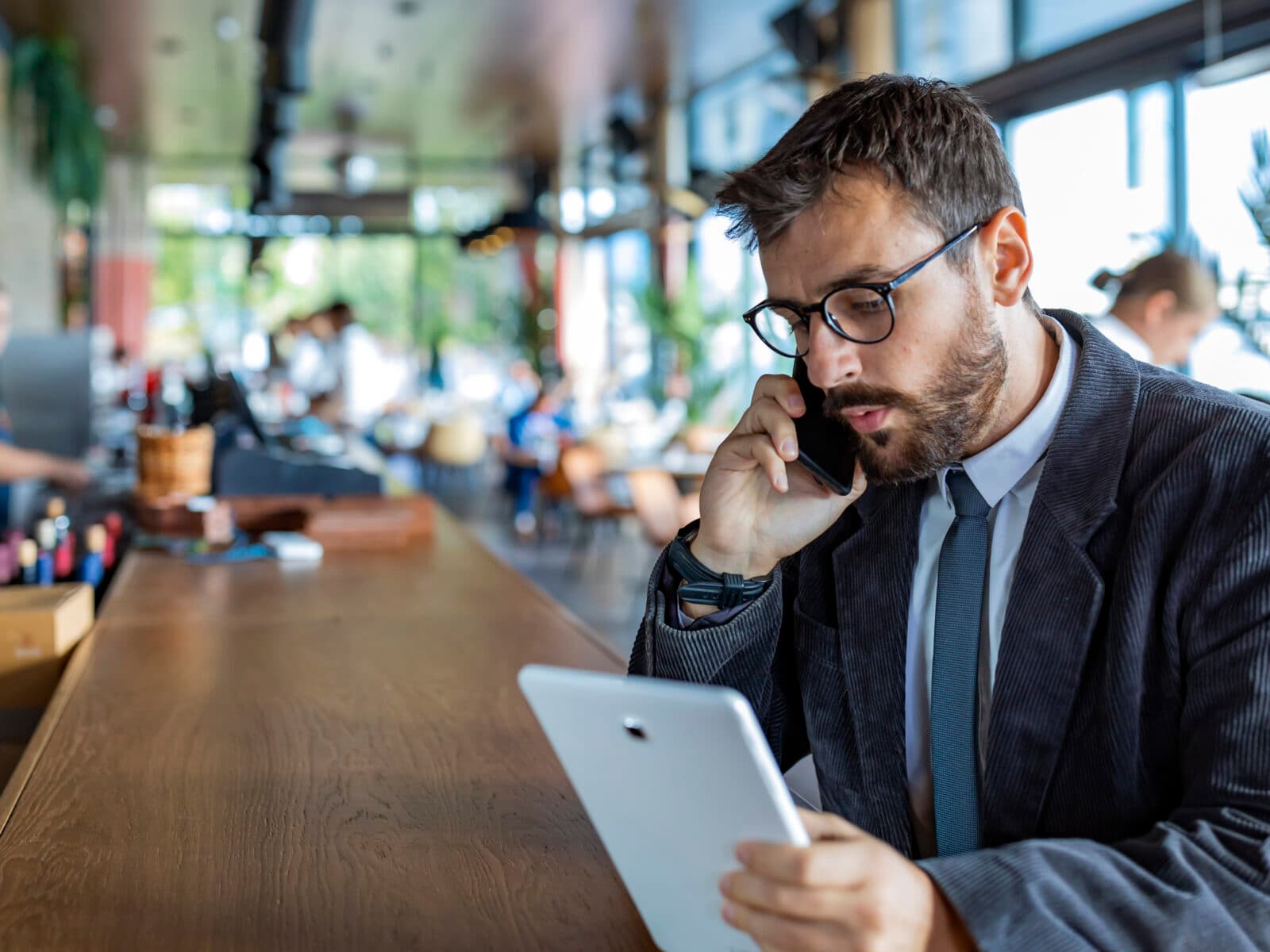 Happy and Successful Male Business Person with Beard, Dressed in Casual Suit is Communicating over a ...