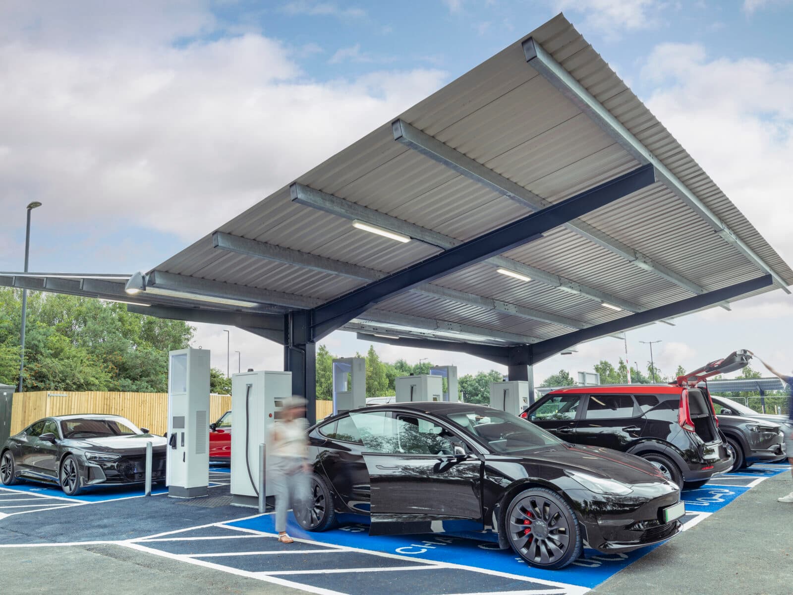 Elbilar laddas vid laddstatation.