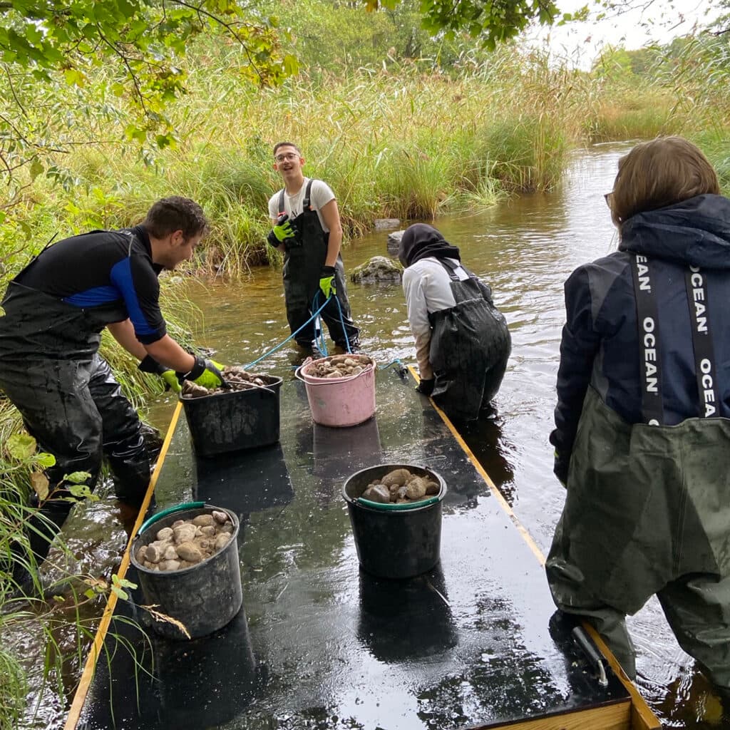 Gymnasieelever restaurerar hotade vattendrag.